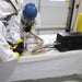 Operator in protective clothing using an Atrix VACOMEGAH beside a window frame