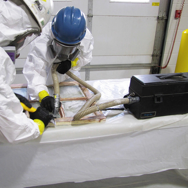 Operator in protective clothing using an Atrix VACOMEGAH beside a window frame