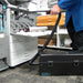 Technician using an Atrix VACOMEGASLFH beside an open copier