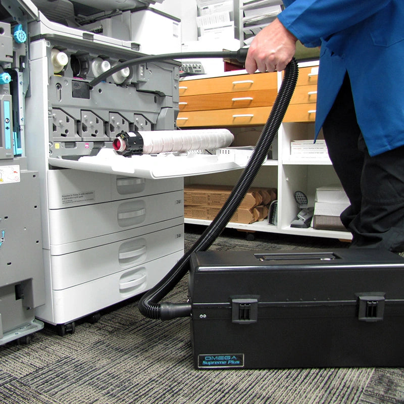Technician using an Atrix VACOSE110 during copier maintenance