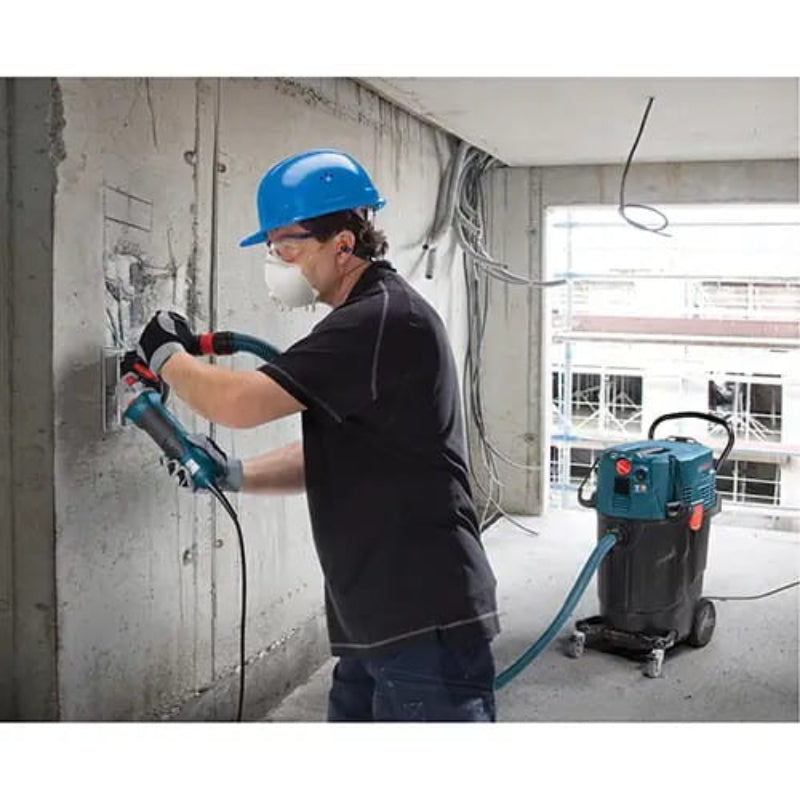 Contractor using the Bosch VAC140AH HEPA dust extractor for indoor dust collection during renovation