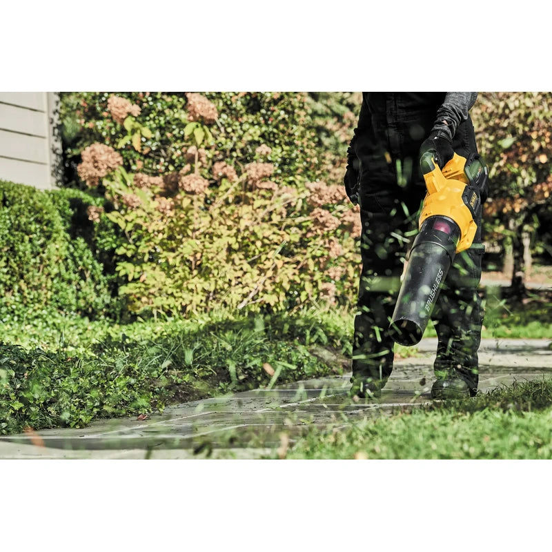 DEWALT DCBL772B cordless blower clearing grass from a walkway