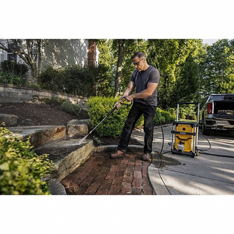 DEWALT electric pressure washer being used to clean a stone patio and outdoor surfaces