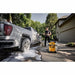 DEWALT 15 Amp electric pressure washer cleaning an SUV driveway and exterior surfaces