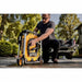 User transporting DEWALT brushless electric pressure washer with portable wheeled design