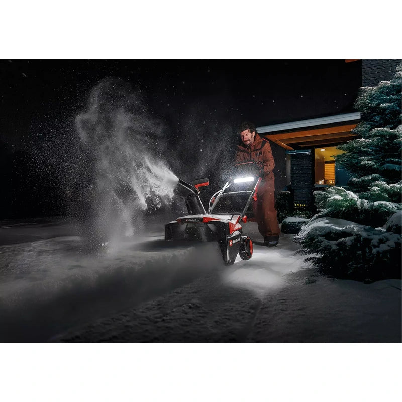 Einhell snowblower clearing snow outdoors at night