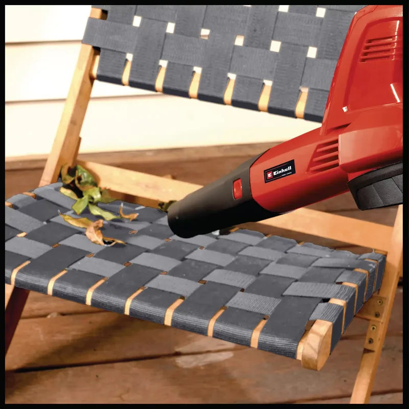 Einhell 3433543 cordless blower with short tube cleaning an outdoor chair