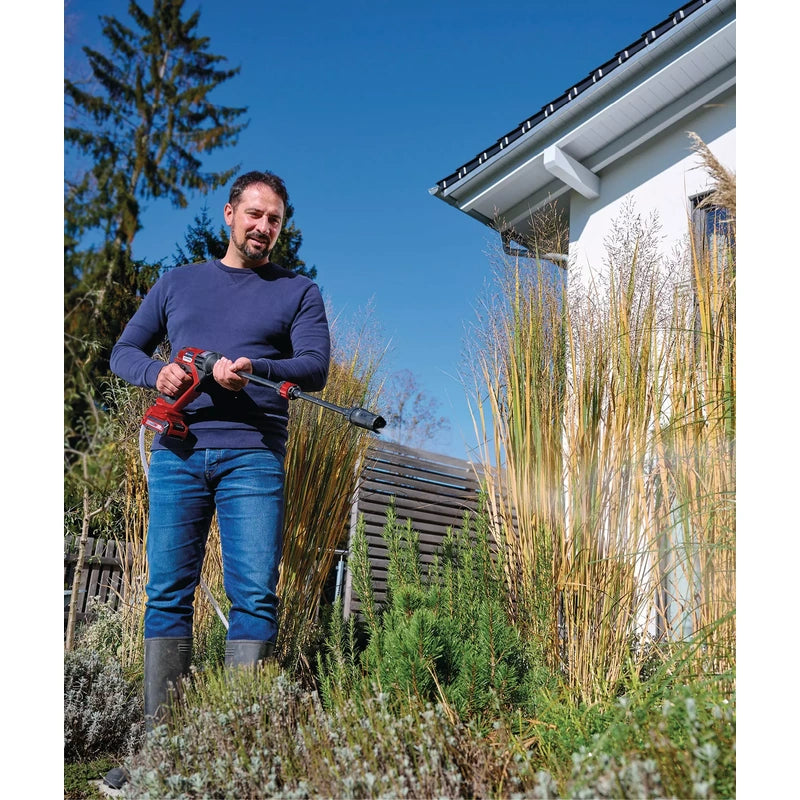 Person using the Einhell HYPRESSO pressure washer to water garden plants