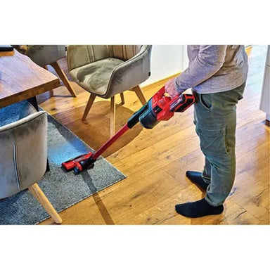 Einhell cordless stick vacuum cleaning hard floors in a commercial workspace