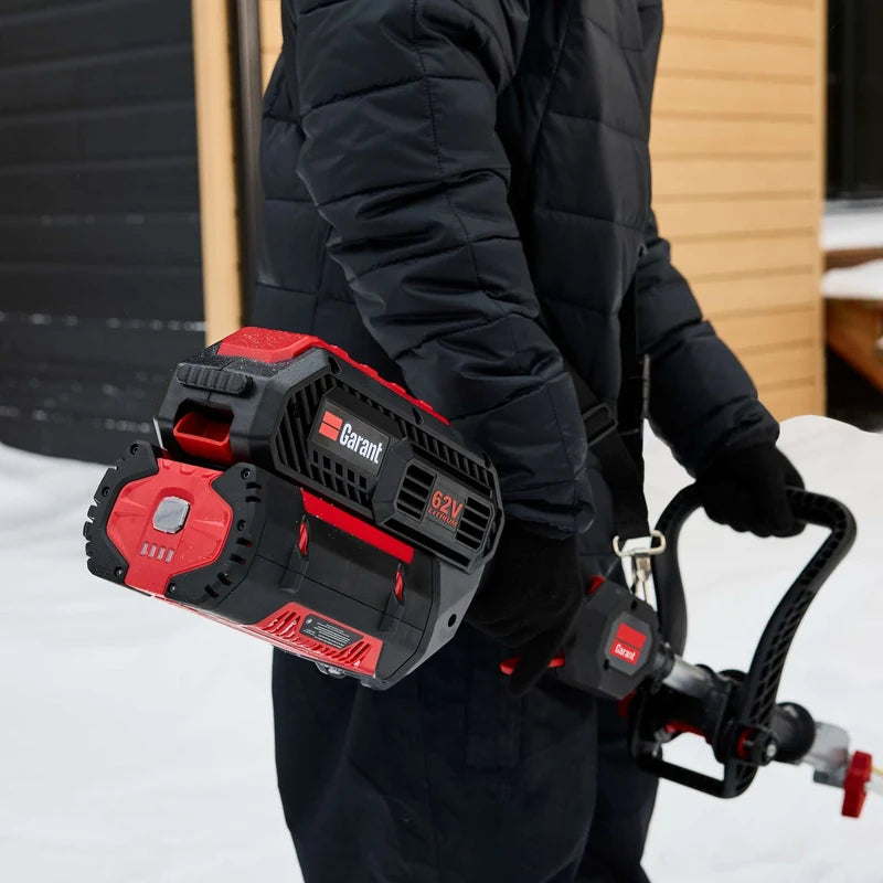 Operator installing the 62V battery on a Garant 85805 cordless snow shovel