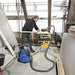 Nilfisk AERO 26 commercial vacuum cleaning dust and debris in a workshop environment