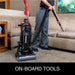 Operator using the Sanitaire SC5745D hose and wand to clean upholstery beside the upright